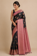 A woman modeling a black and dusty pink saree with gold motifs and a pink border.