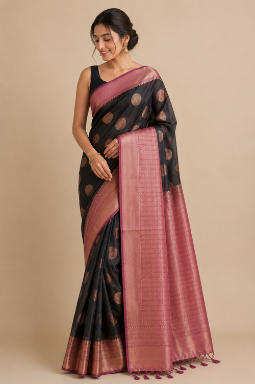 A woman modeling a black and dusty pink saree with gold motifs and a pink border.