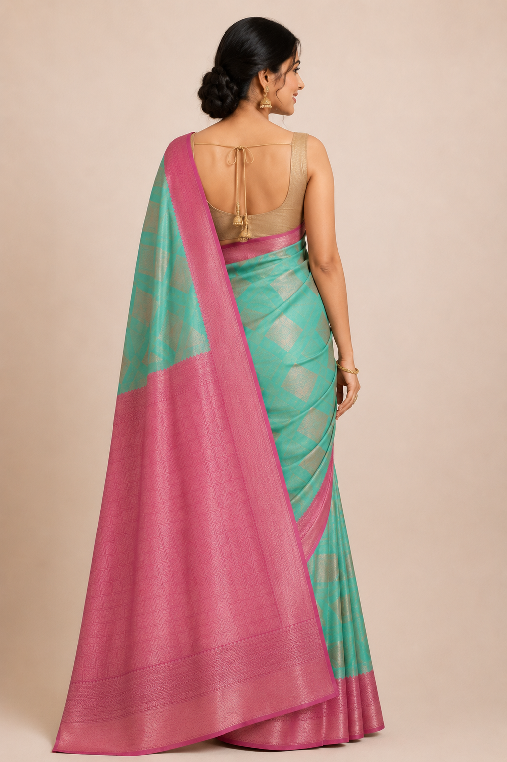 A woman shown from the back wearing a green and pink saree with a beige blouse.