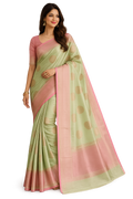 A woman modeling a light green and pink saree with gold polka dots and a pink border, paired with a solid pink blouse, against a plain white background.
